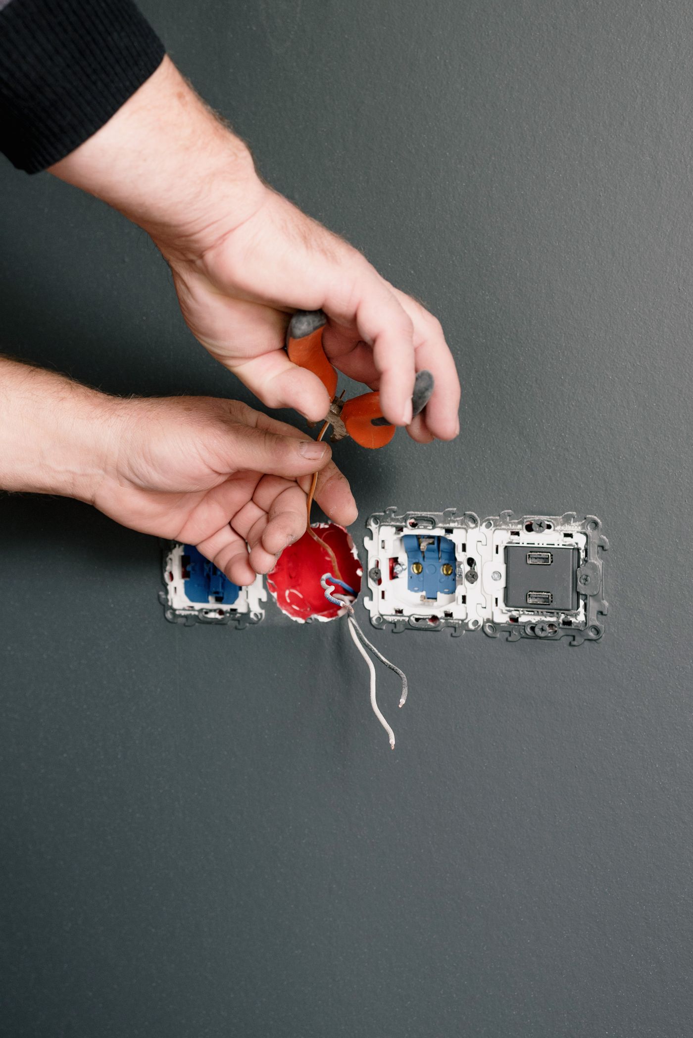 Profesional reparando una instalación eléctrica con herramientas